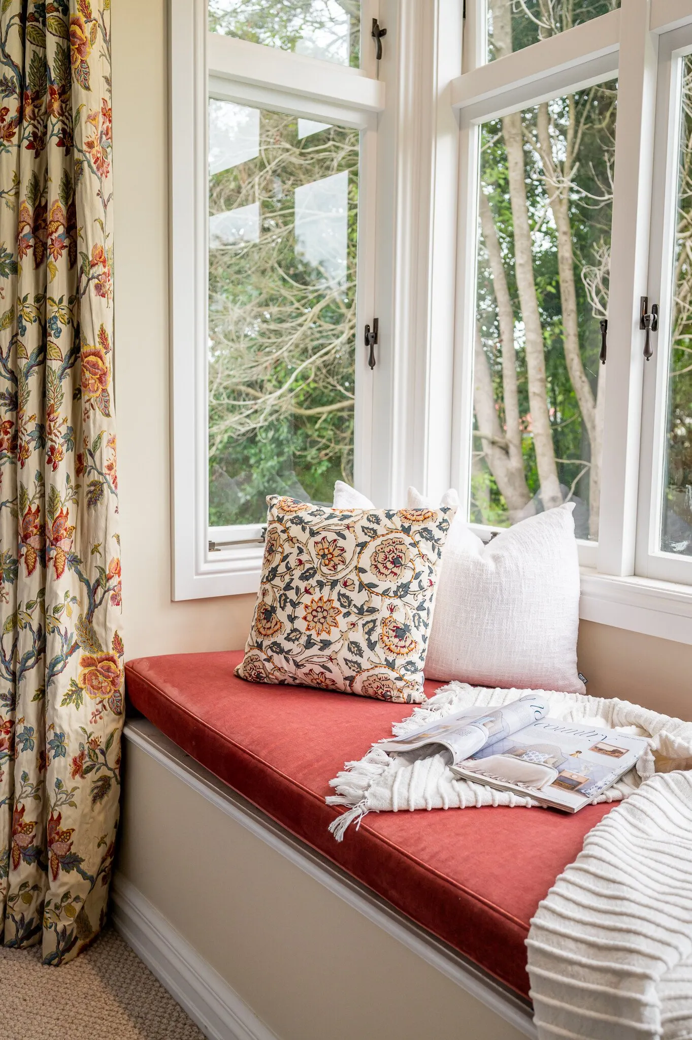 Close up image of window seat and floral print cushion and curtains in newly renovated master bedroom. Renovated by local Te Awamutu residential builders, Whitechurch Construction.