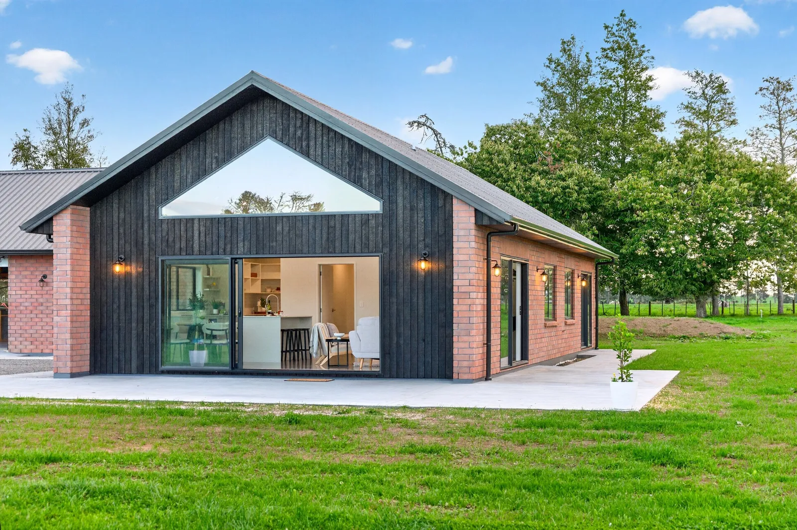Red brick cladded home with burnt Japanese cedar feature gable. New build by Whitechurch Construction, Te Awamutu builders.