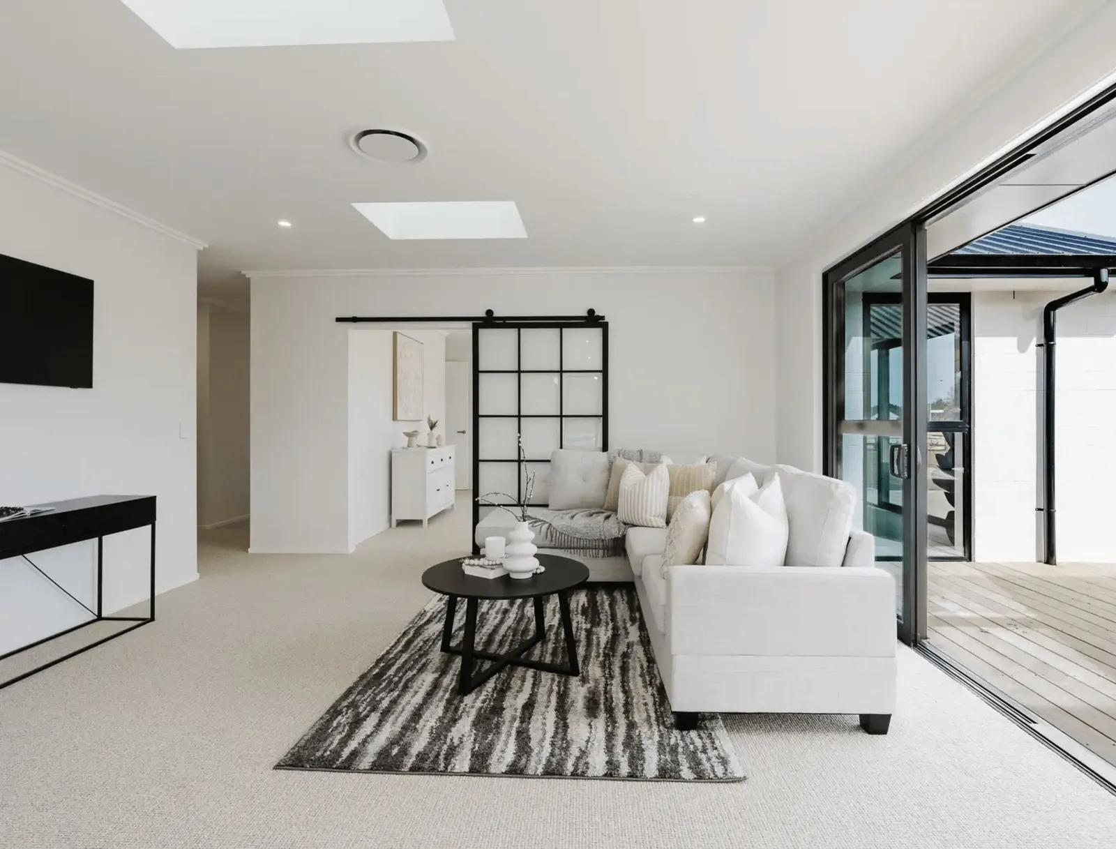 Image of natural light filled lounge with modern large white comfy lounges suite in Collinson Street, Pirongia new home, by Waikato residential builders Whitechurch Construction Limited.