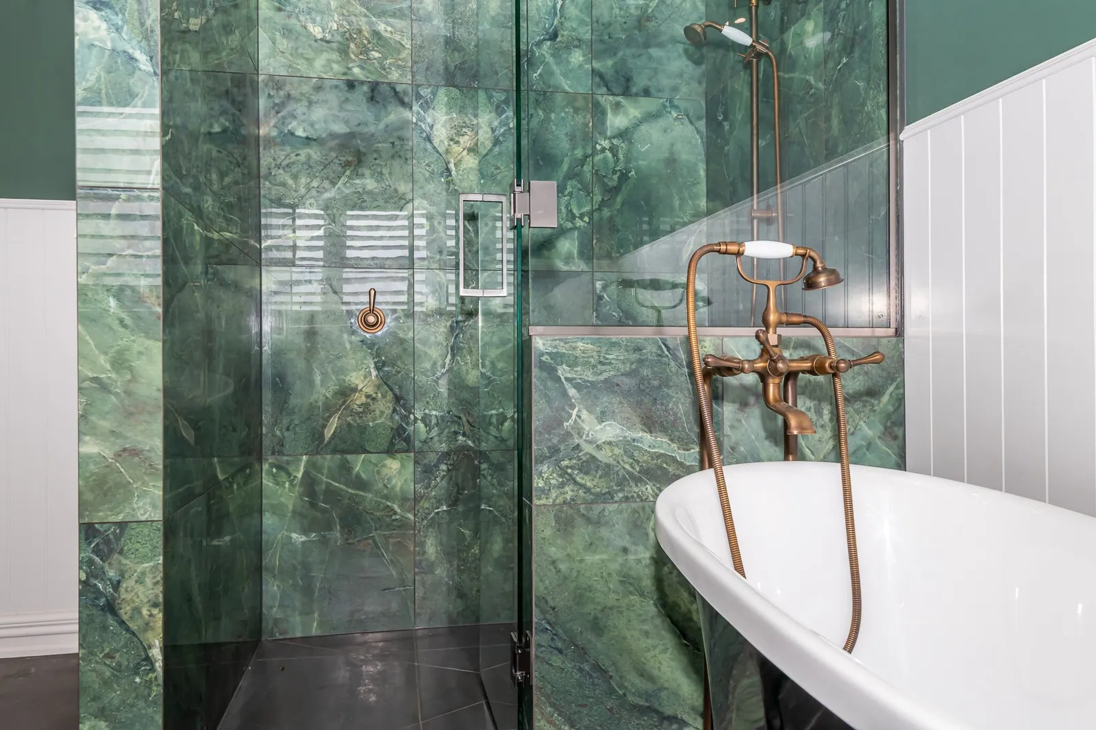Close up image of claw bath and green marble tiled shower in renovated heritage bathroom. Renovated by local Te Awamutu residential builders, Whitechurch Construction.