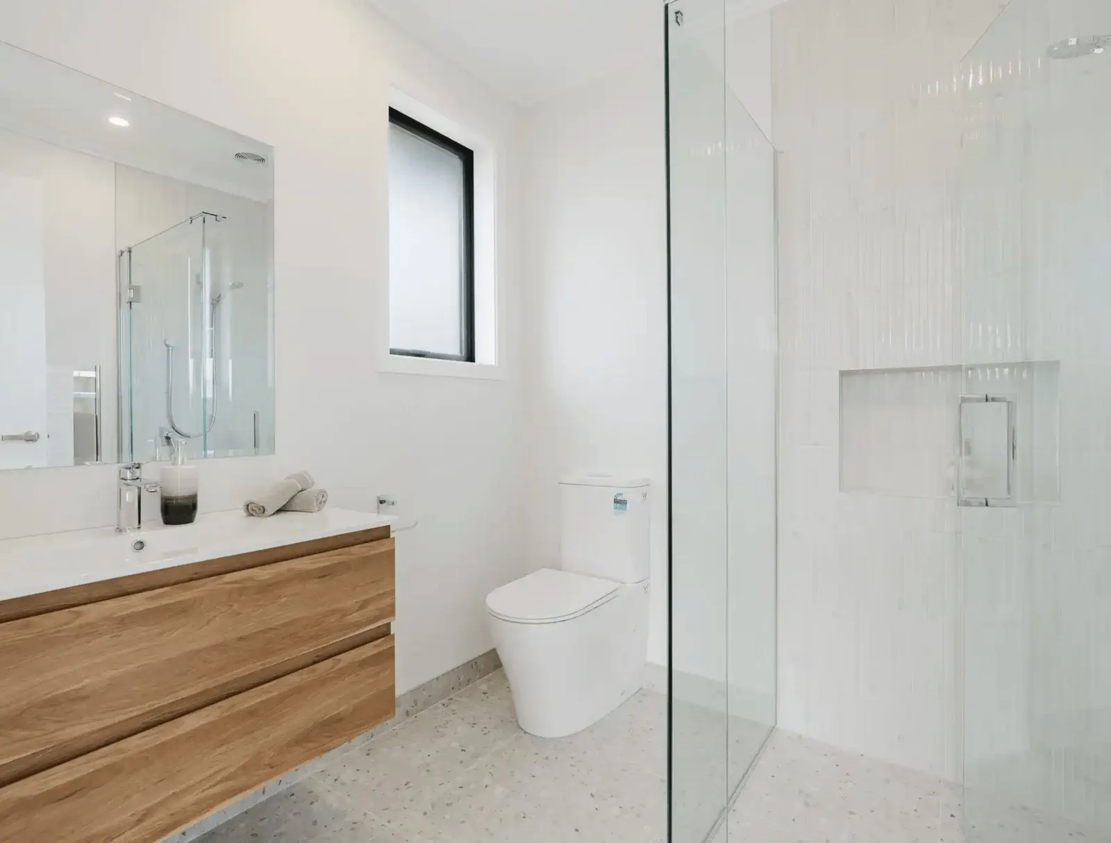 Image of modern neutral ensuite with timber cabinetry and pale grey tiling in Collinson Street, Pirongia new home, by Waikato residential builders Whitechurch Construction Limited.