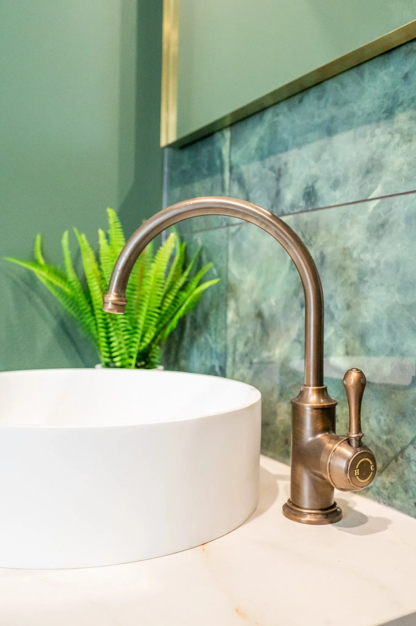 Close up image of copper tap in newly deep sage & white renovated heritage bathroom. Renovated by local Te Awamutu residential builders, Whitechurch Construction.