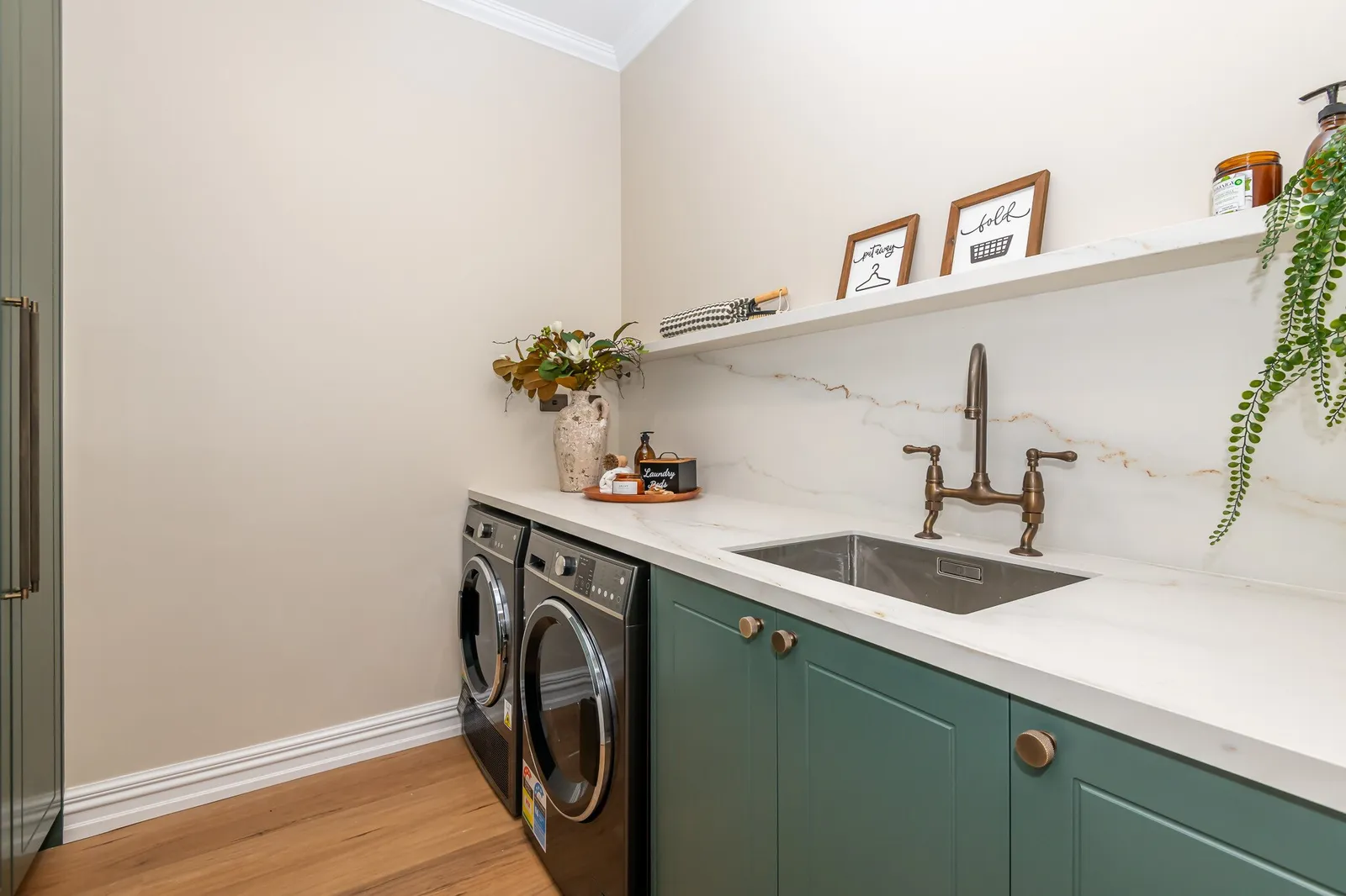 Image of newly renovated heritage laundry room in deep sage & white. Renovated by local Te Awamutu residential builders, Whitechurch Construction.