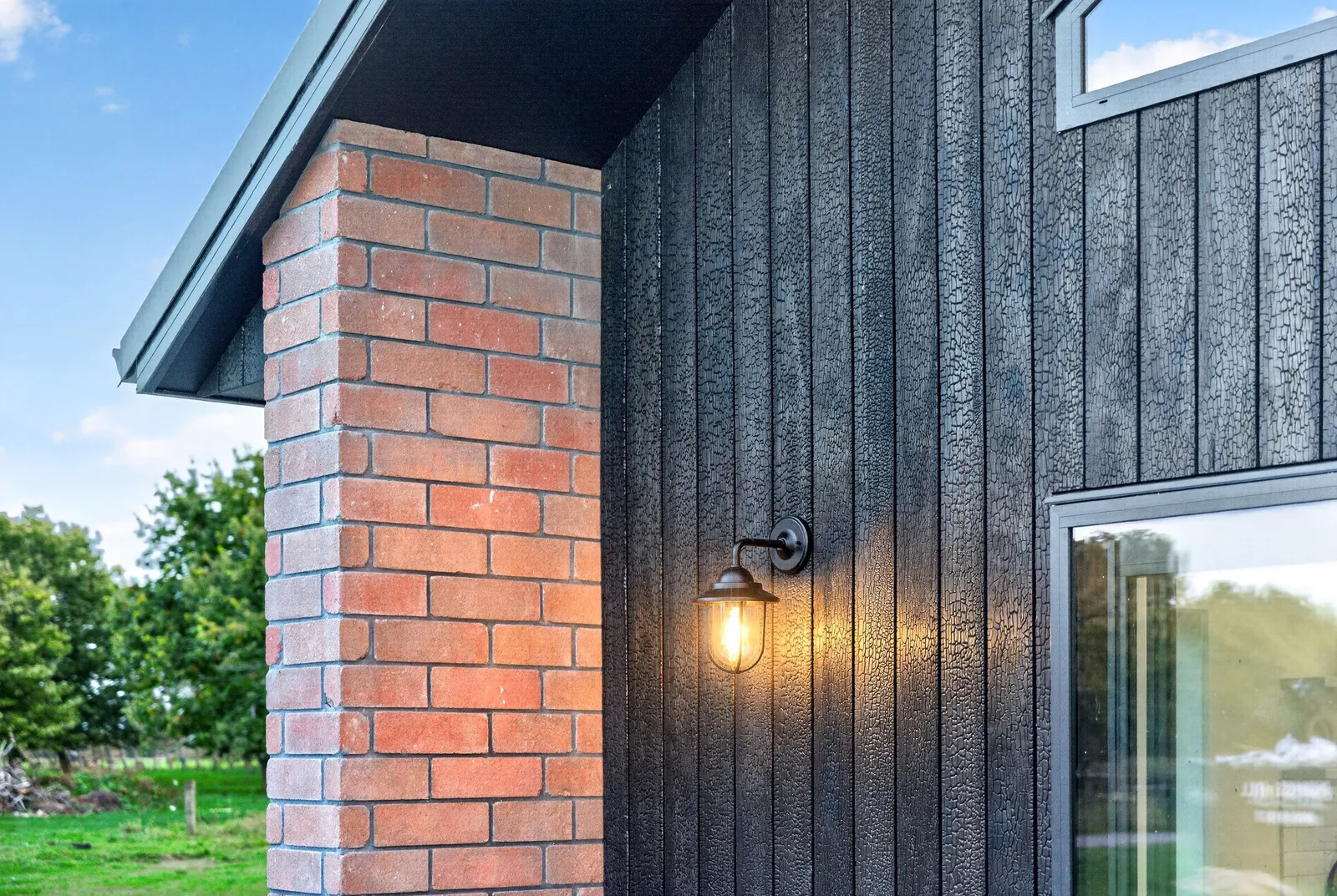 Red brick home with burnt Japanese cedar feature gable end by Whitechurch Construction, Te Awamutu builders.