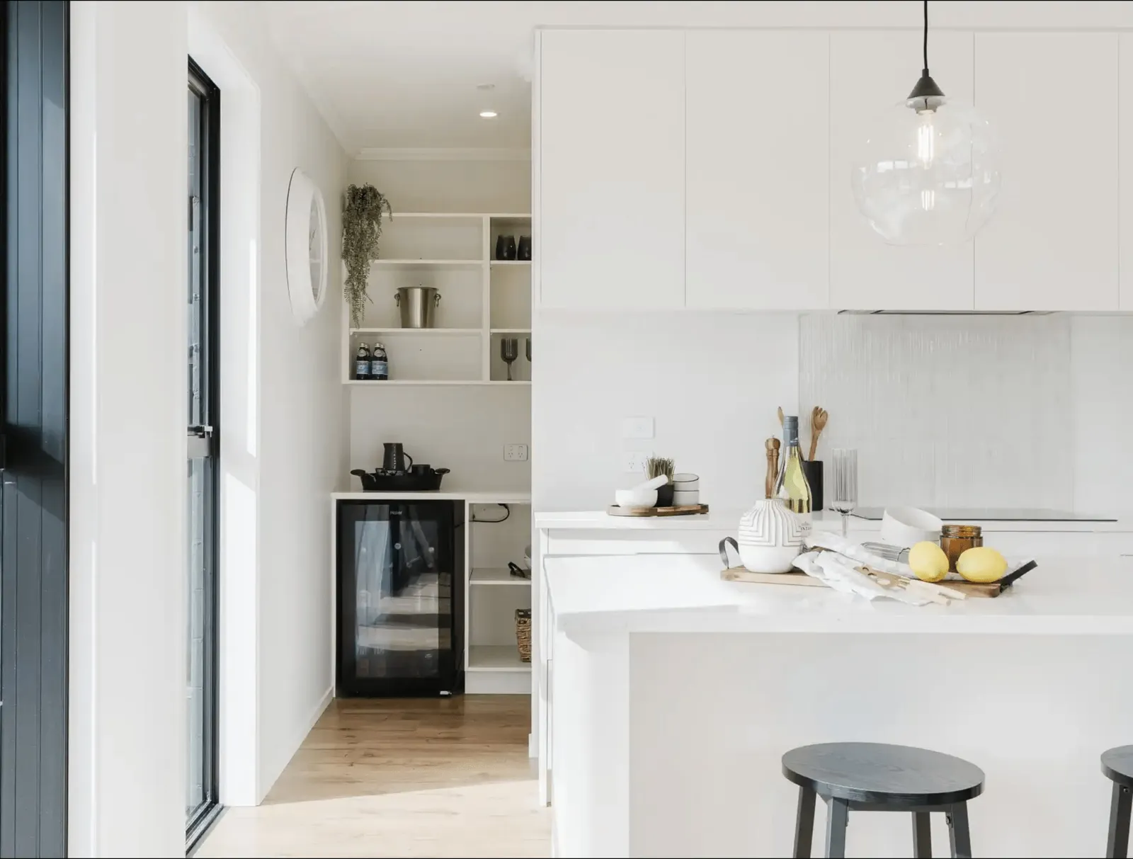 Image of light filled white kitchen and modern black appliances in Collinson Street, Pirongia new home, by Waikato residential builders Whitechurch Construction Limited.