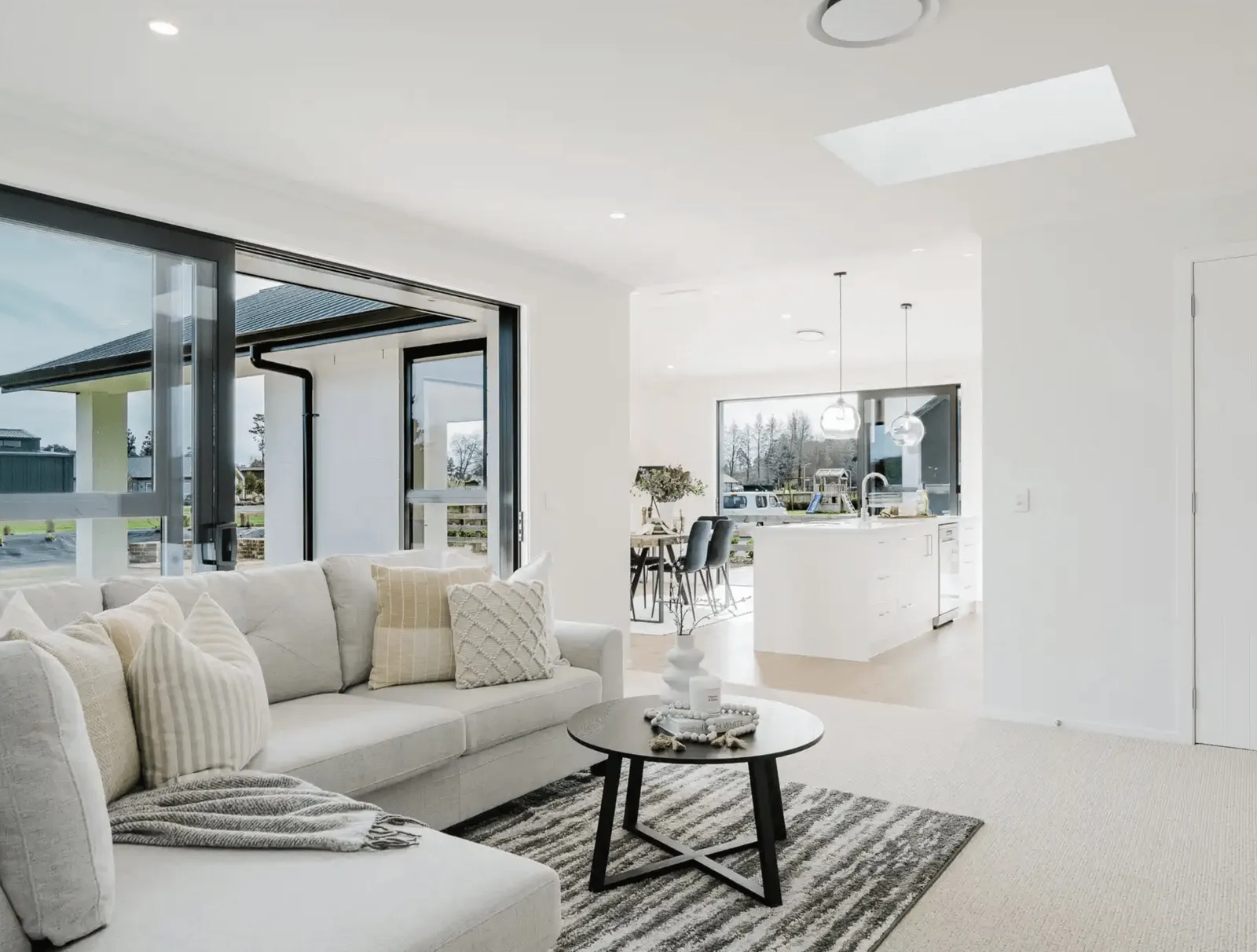 Image of natural light filled lounge with modern large white comfy lounges suite in Collinson Street, Pirongia new home, by Waikato residential builders Whitechurch Construction Limited.