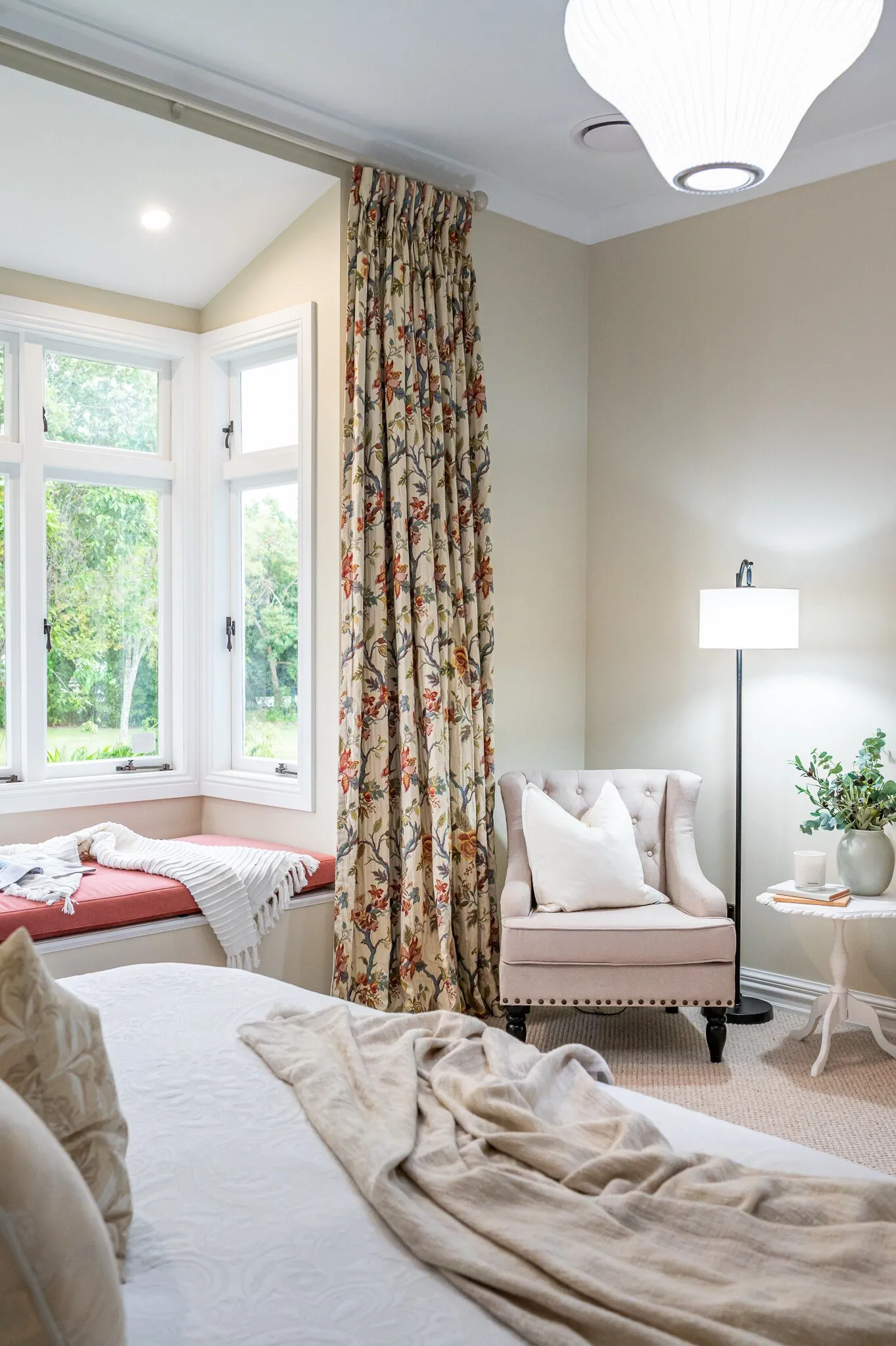 Image of newly renovated master bedroom in sand with floral print curtains and window seat. Renovated by local Te Awamutu residential builders, Whitechurch Construction.