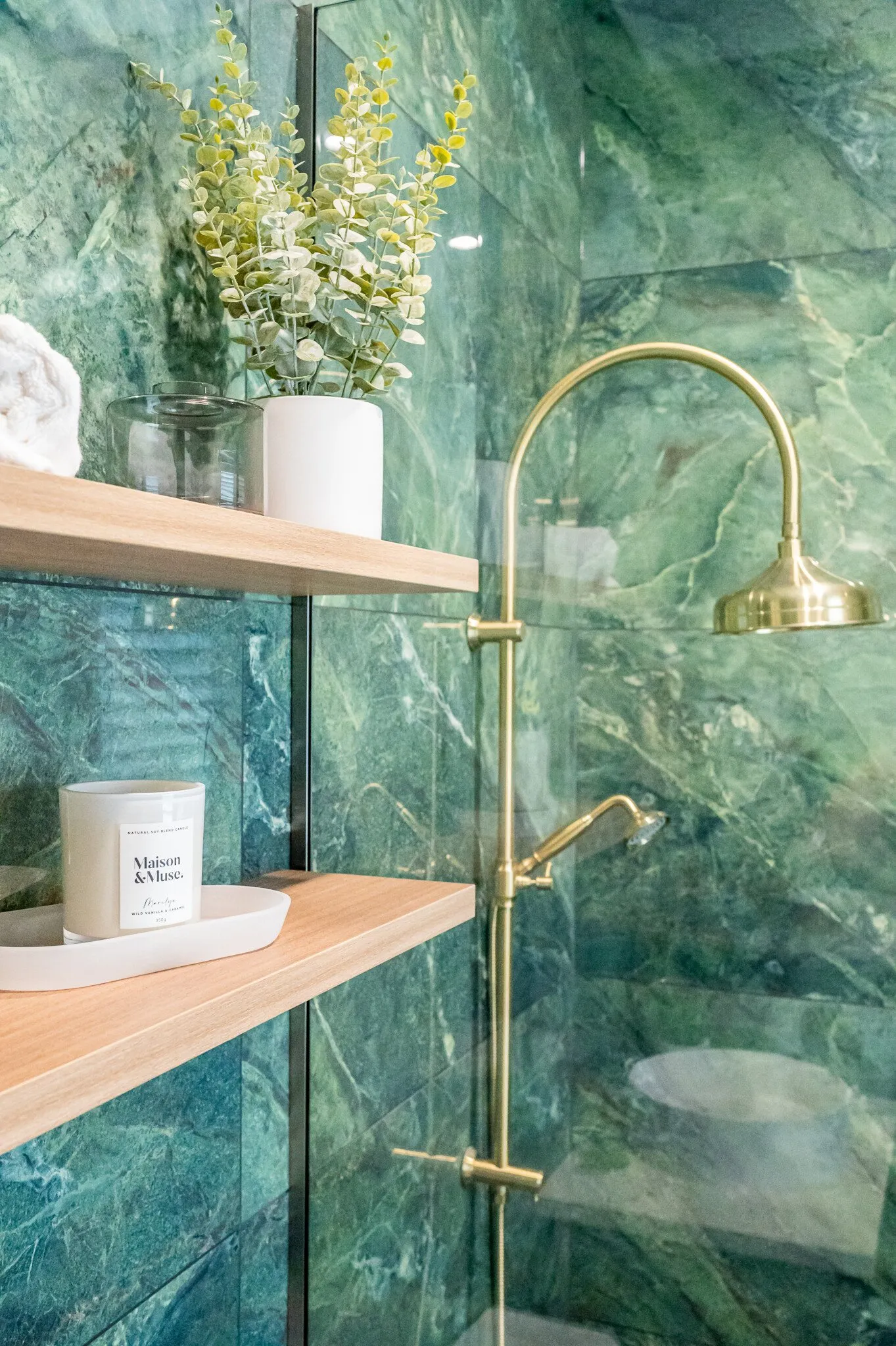 Close up image of brass shower head in green marble tiled shower in renovated heritage bathroom. Renovated by local Te Awamutu residential builders, Whitechurch Construction.