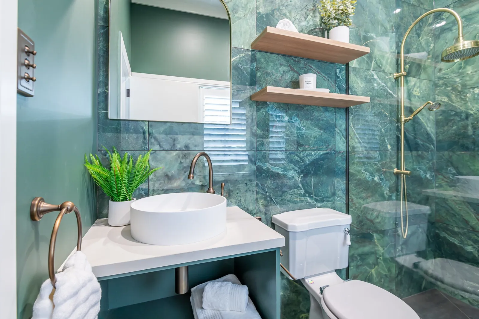 Image of newly renovated heritage bathroom in deep sage & white. Oval mirrors and round basins. Renovated by local Te Awamutu residential builders, Whitechurch Construction.