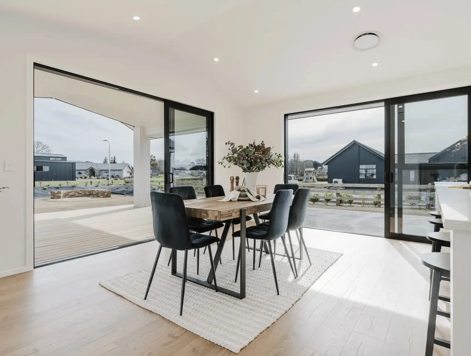 Image of natural light filled dining area with modern table and chair styling in Collinson Street, Pirongia new home, by Waikato residential builders Whitechurch Construction Limited.
