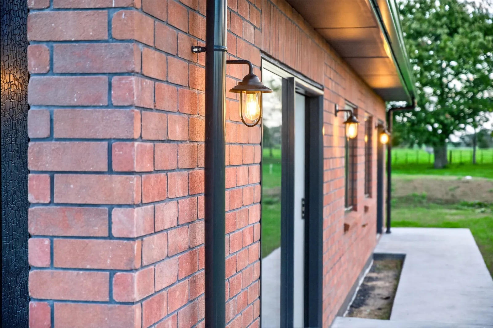 Red brick home with feature lighting by Whitechurch Construction, Te Awamutu builders.