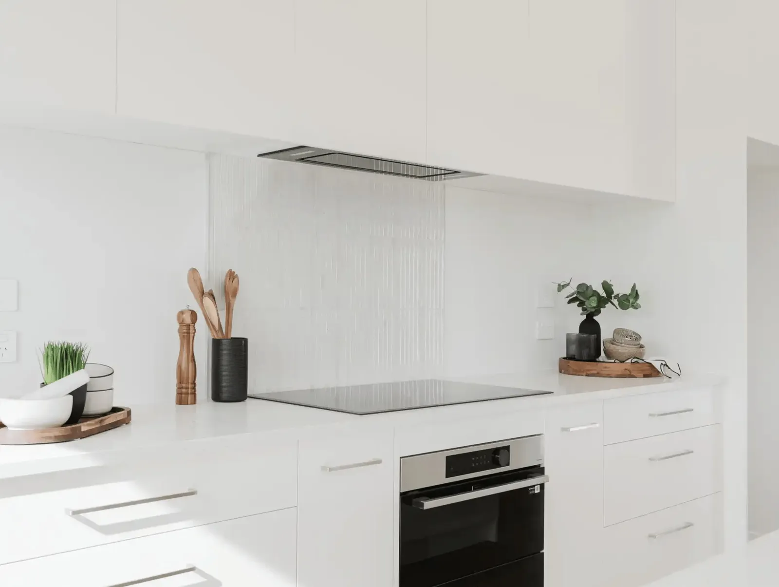 Image of light filled white kitchen and modern black appliances in Collinson Street, Pirongia new home, by Waikato residential builders Whitechurch Construction Limited.