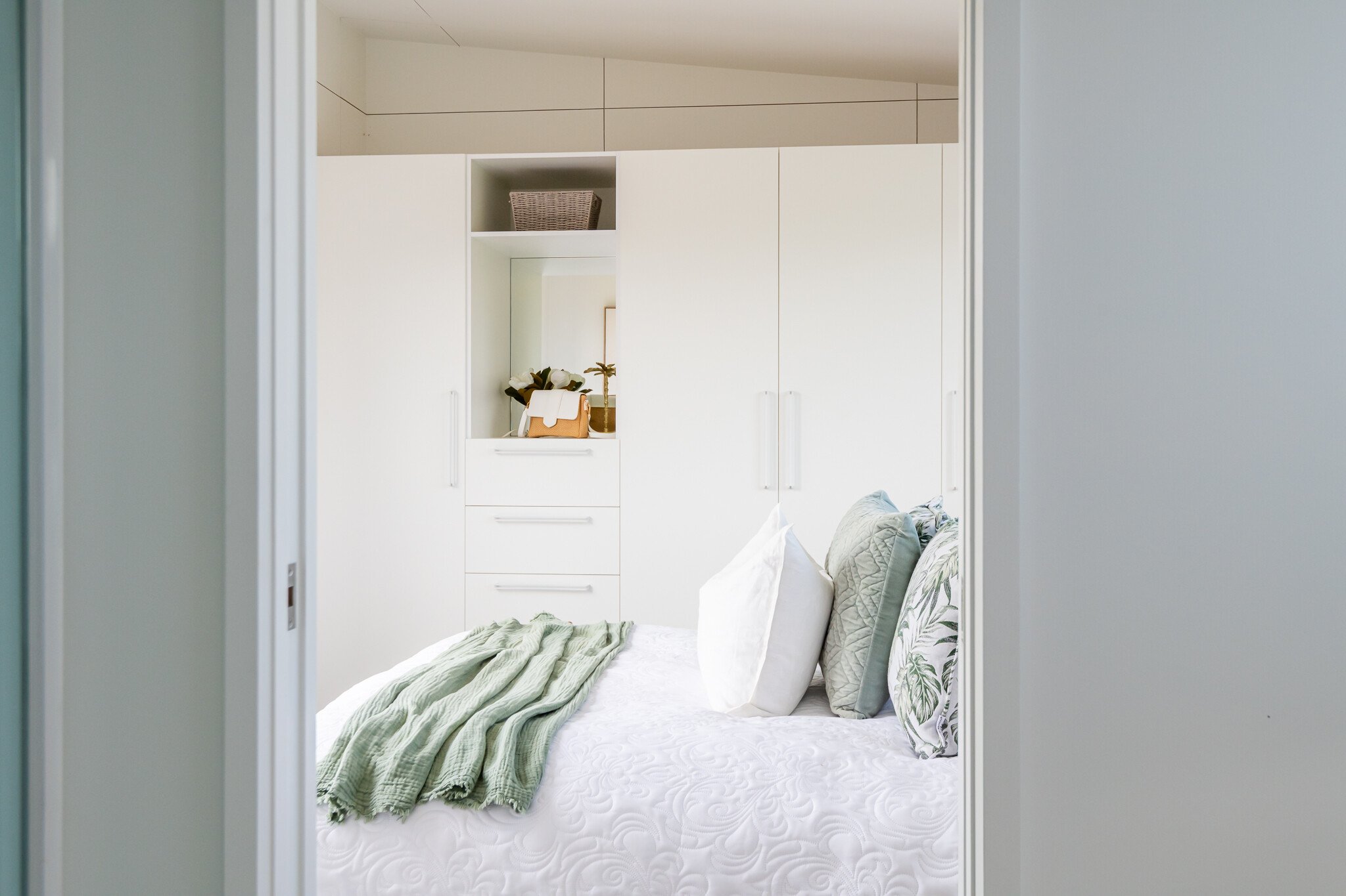 View of bed and storage cupboards in bedroom